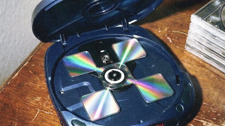 A Discman on a wooden table with NEW MONEY printed on it